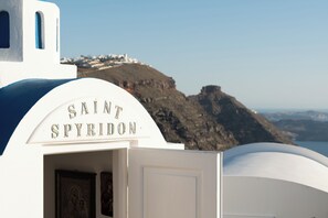 Un bâtiment blanc sur lequel on peut lire l’inscription « SAINT SPYRIDON », avec une porte et une petite fenêtre.