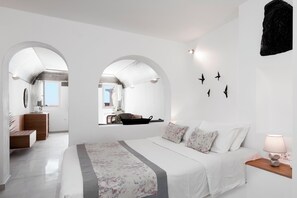 Un dormitorio moderno con una cama grande, una mesita de noche de madera, un escritorio y vistas a través de un ventanal arqueado.