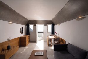 A modern living room with a sofa, coffee table, and wooden sideboard. - Santorini Princess Spa Hotel (Santorini)