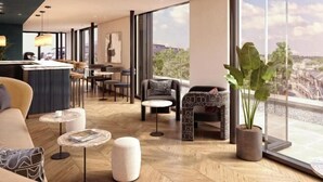 A modern hotel lobby with a bar, seating area, and large windows offering city views. - The Store (Oxford)