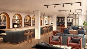 A modern lounge area with a bar, seating, and a view of the kitchen. - The Store (Oxford)