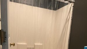 A bathroom with a shower curtain, a toilet, and a bathtub. - Glendale Inn (Glendale)