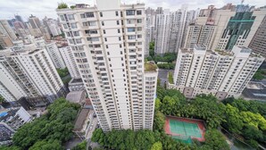 A high-rise residential building with multiple balconies, surrounded by other high-rise buildings and greenery. - Tyms Spacious 3BR 2BA APT  Laishi Di (Shanghai)