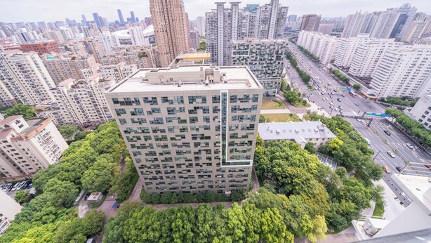 A high-rise building with a modern architectural design, surrounded by other high-rise buildings and a busy street below. - Tyms Yadu Business 1BR APT   (Shanghai)