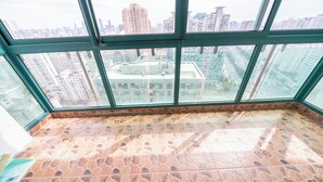A high-rise interior with a panoramic city view through large windows. - Tyms Yadu Business 1BR APT   (Shanghai)