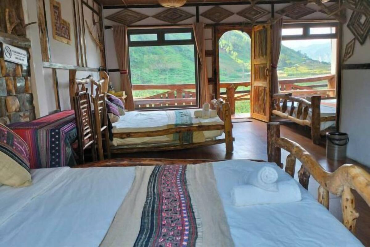 Ein Zimmer mit einem Bett, Holzmöbeln und Blick auf eine Berglandschaft.