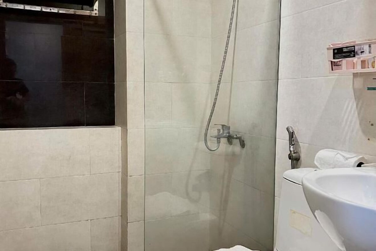 A bathroom with a shower, a sink, and a mirror.