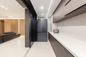 Un vestíbulo de hotel moderno con mostrador de recepción, zona de estar y una escalera que lleva a un ascensor.
