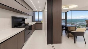 A modern kitchen with a large island, a dining area with a view, and a large window.