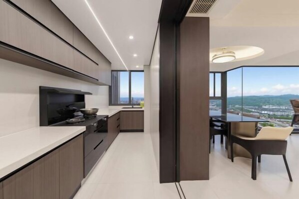 A modern kitchen with a large island, a dining area with a view, and a large window. - My Heart Returns · Zhangjiajie Zero-Pressure Luxury Dream Apartment (Zhangjiajie)