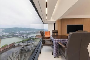 A modern room with a glass balcony, a dining table, and a TV. - My Heart Returns · Zhangjiajie Zero-Pressure Luxury Dream Apartment (Zhangjiajie)