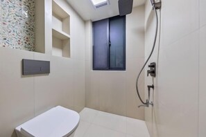 A small, modern bathroom with a toilet, a shower, and a window. - My Heart Returns · Zhangjiajie Zero-Pressure Luxury Dream Apartment (Zhangjiajie)