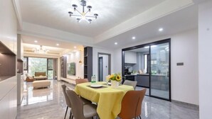 A modern dining area with a table, chairs, and a chandelier.
