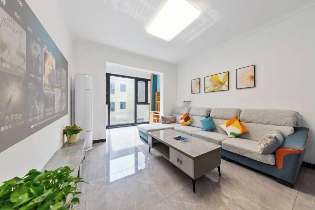 A modern living room with a sofa, coffee table, and artwork on the wall.