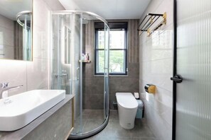 A modern bathroom with a glass-enclosed shower, a white sink, and a toilet. - My Heart Returns · Zhangjiajie Zero-Pressure Luxury Dream Apartment (Zhangjiajie)