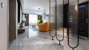 A modern interior with a polished floor, a seating area with a sofa, and a decorative plant.