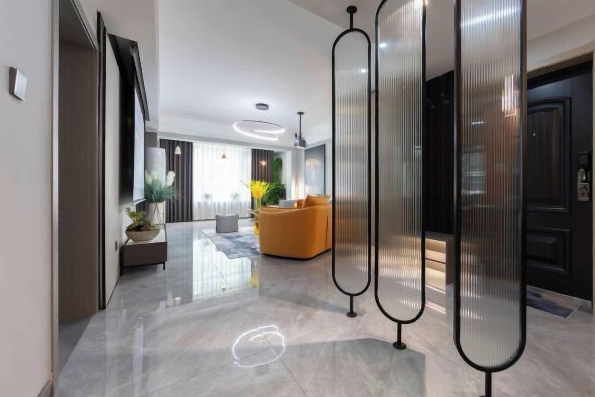 A modern interior with a polished floor, a seating area with a sofa, and a decorative plant.