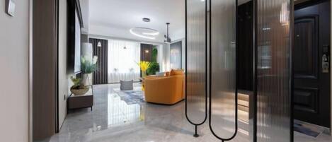A modern interior with a polished floor, a seating area with a sofa, and a decorative plant.