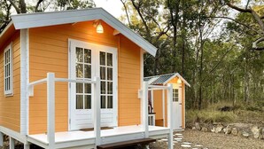 A small wooden cabin with a porch and steps leading up to the entrance. - Casa Naranja | Off-grid Hideaway Agnes Water 1770 (Captain Creek)