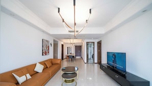 A modern living room with a sofa, a coffee table, and a TV on a black entertainment unit. - Tyms Xintiandi Elegant 3BR 2BA APT  (Shanghai)