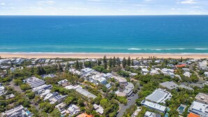 Una vista aerea di una zona residenziale sul lungomare, con case, spiaggia e oceano.