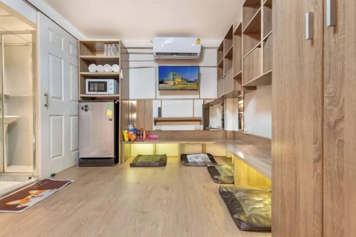 Eine kleine Küche mit Mikrowelle, Kühlschrank und eingebauten Regalen.