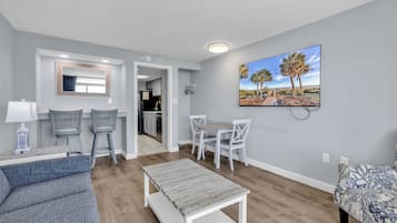Condo com design assinado, 1 quarto, sacada, vista para o oceano | Sala de estar | Smart TV 65 polegadas com canais digitais