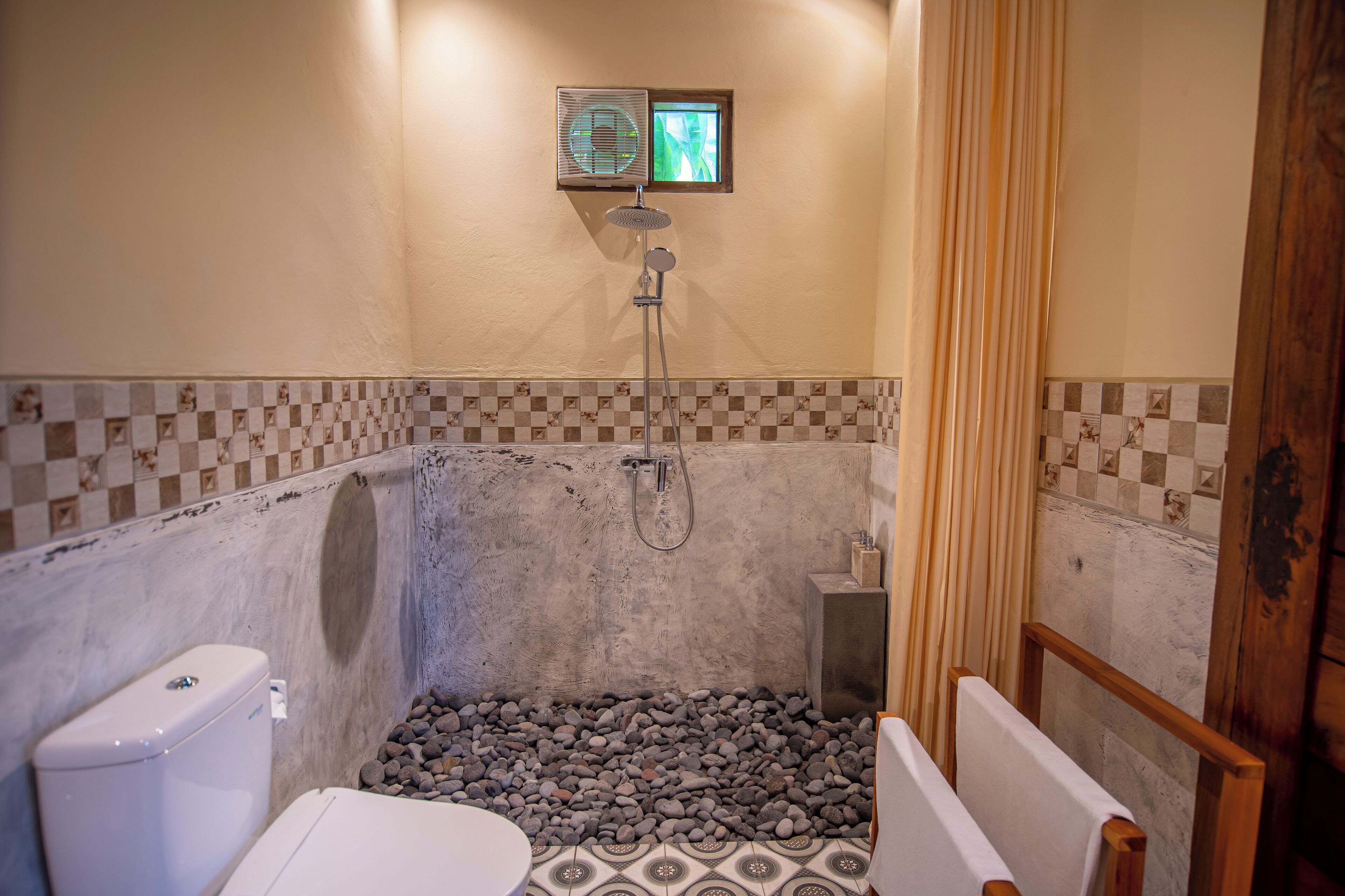 A bathroom with a shower, a toilet, and a small sink.