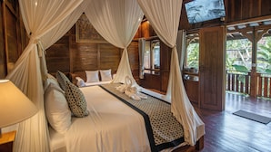 A bedroom with a canopy bed, a television, and a view of the outdoors. - Kerjim Wooden Villa (Sukawati)