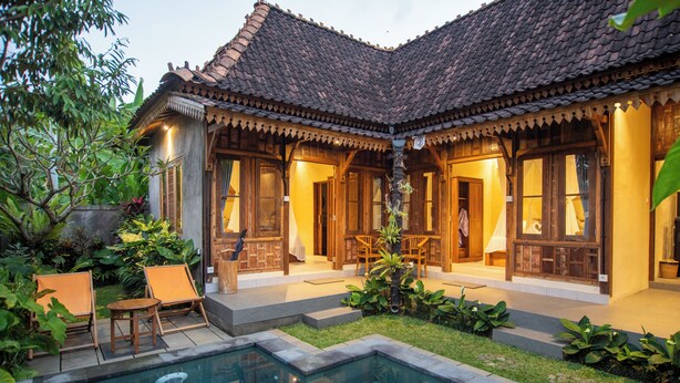 A traditional house with a tiled roof, a swimming pool, and outdoor seating. - Kerjim Wooden Villa (Sukawati)