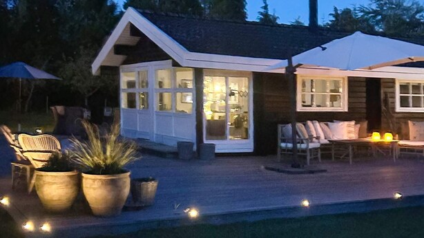 A modern house with a large glass door, a patio with outdoor furniture, and a swimming pool. - 4 Star Holiday Home in Vaeggerlose (Vaeggerlose)