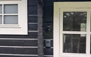 Eine Holzwand mit einem weißen Fensterrahmen und einer Tür.