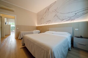 A hotel room with two beds, a large wall mural, a wooden floor, and a view through an open door. - Residence Stella (Massa)