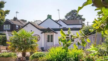 Une maison d’habitation dotée d’un jardin bien entretenu, d’un chemin menant à l’entrée et offrant une vue dégagée sur le quartier environnant.