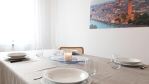 A dining table set with plates, glasses, a candle, and cutlery. - Myarenaverona (Verona)