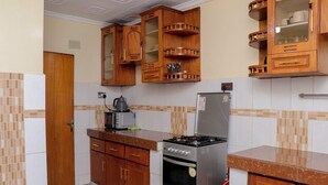 A kitchen with wooden cabinets, a stainless steel stove, and a microwave.