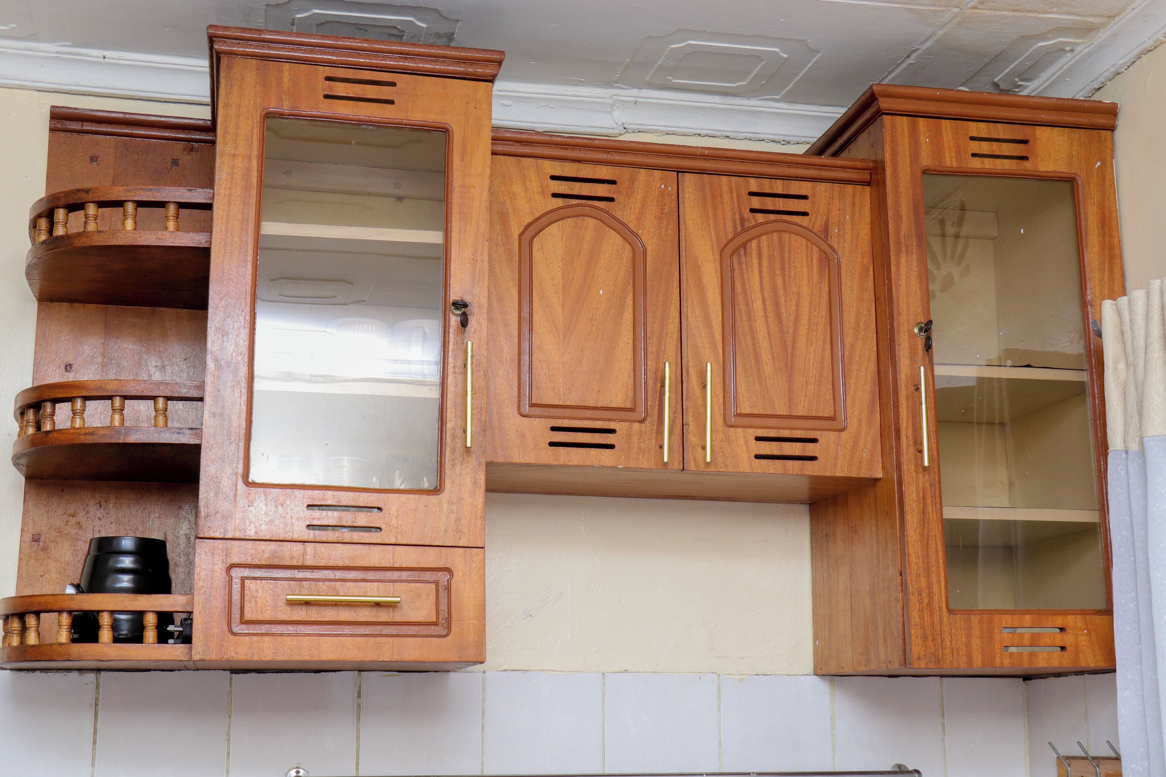 Une cuisine avec des meubles de rangement en bois, un plan de travail et un évier.