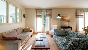 A living room with a sofa, a coffee table, and a patterned sofa. - LE COTTAGE - Charming 3 double bedroom villa - 10 minutes from the ocean (Saint-Julien-en-Born)
