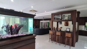 A modern interior with a bar area, a large aquarium, and a seating section. - ViewPoint Villa (Phuket)