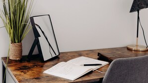 A wooden desk with a notebook, pen, and a framed picture. - Vacation Apartment Rental - La Suite D'Hélène in Scionzier (Scionzier)
