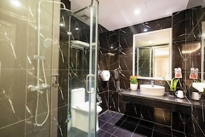 A modern bathroom with a glass-enclosed shower, a white toilet, and a vanity with a sink and mirror. - Kieu Anh Hotel Ha Noi (Hanoi)