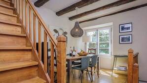 A wooden staircase leading to a dining area with a table, chairs, and a hanging light fixture. - Miramonde, romantic holiday home (Savignac-de-Miremont)