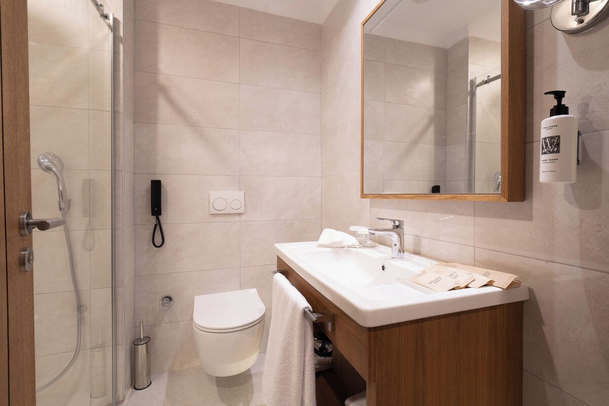 A modern bathroom with a shower, toilet, and sink.