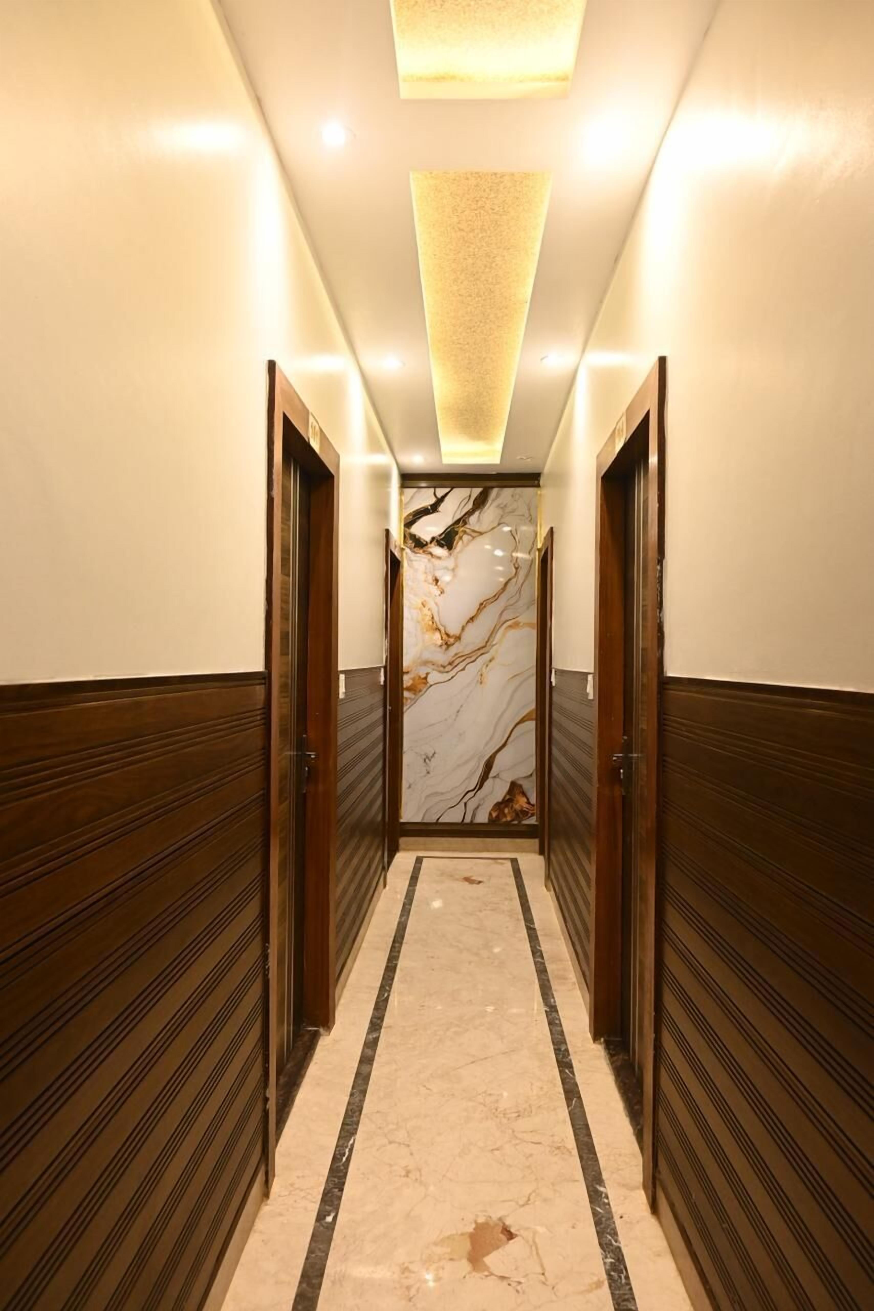 Egy folyosó, melynek falait fa borítással látták ki, egy márványfal és egy mennyezeti lámpatest található benne.