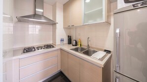Una cocina moderna con electrodomésticos de acero inoxidable, un lavamanos doble y armarios de color claro.