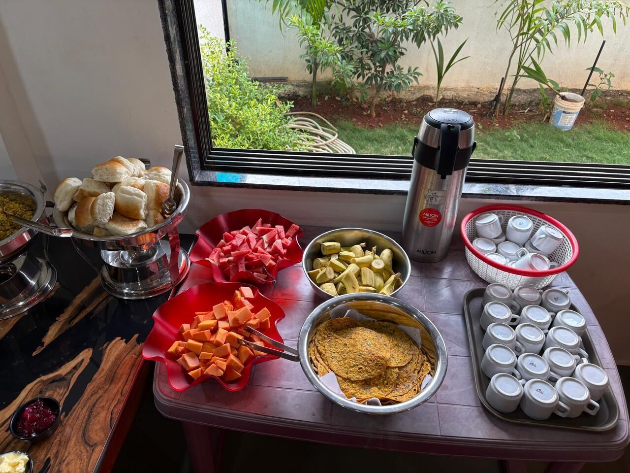 A buffet table with various food items and utensils.