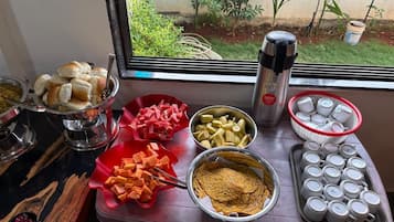 A buffet table with various food items and utensils.