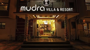 The entrance of Mudra Villa & Resort with a sign above the door and a staircase leading inside. - Mudra Villa & Resort (Nagaon)