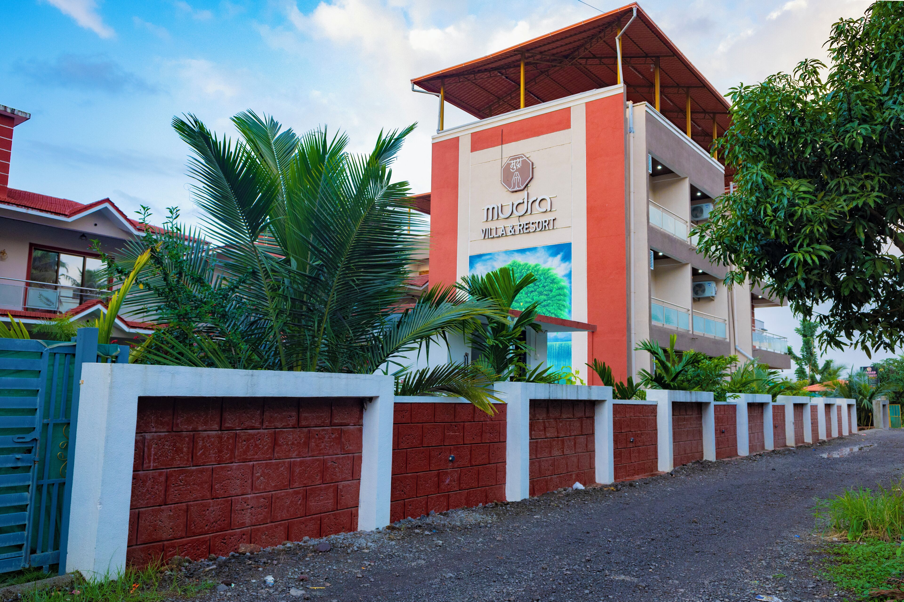 A multi-story building with a sign for 'Mudra Villa & Resort'.