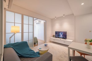 Apartamento superior, 1 quarto, micro-ondas, vista para a cidade | Sala de estar | Smart TV 55 polegadas com canais a cabo